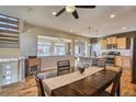 Open-concept dining area with hardwood floors, connecting seamlessly to the kitchen and a cozy living space at 5295 Andes St, Denver, CO 80249