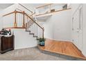 Inviting foyer features a staircase with wood and white trim, carpeted steps, and hardwood flooring at 5146 S Argonne St, Centennial, CO 80015