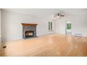 Bright living room with hardwood floors, vaulted ceiling, and a cozy stone fireplace at 2750 S Rifle St, Aurora, CO 80013