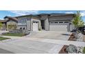 Expansive concrete driveway leading to a two-car garage, complemented by stone accents and landscaping at 2144 Bellcove Dr, Castle Pines, CO 80108