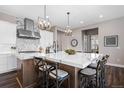 Kitchen island with stylish chairs and sink, complemented by stainless steel appliances and modern lighting at 2144 Bellcove Dr, Castle Pines, CO 80108