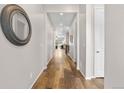 Inviting hallway featuring hardwood floors, neutral paint, leading to living spaces at 9781 Eagle River St, Littleton, CO 80125