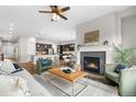 Cozy living room featuring a fireplace, with hardwood floors and a view into the kitchen at 9781 Eagle River St, Littleton, CO 80125