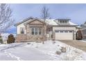 Ranch style home with stone and siding accents, attached garage, and snowy front yard at 1075 Whitekirk Pl, Castle Rock, CO 80104