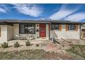 Charming home featuring a red front door, a pleasant entryway, and white painted brick at 327 S Xanadu St, Aurora, CO 80012