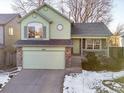 Two-story light green house with attached garage and driveway at 3802 Desert Willow Ave, Broomfield, CO 80020