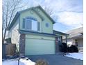 Light green two-story house with a two-car garage and snowy front yard at 3802 Desert Willow Ave, Broomfield, CO 80020