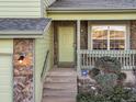 Light green front door with stone accents and a small porch at 3802 Desert Willow Ave, Broomfield, CO 80020