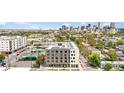Modern multi-story apartment building featuring solar panels on the roof with a city skyline in the distance at 603 Inca St # 530, Denver, CO 80204
