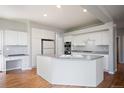 Bright kitchen features white cabinets, a large island, and hardwood floors at 17235 Opal Hill Dr, Parker, CO 80134