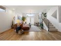 Bright and airy living room with hardwood floors, a brown sectional sofa, and a view of the staircase at 3930 Yates St, Denver, CO 80212