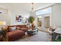 Bright living room featuring a brown sectional sofa, modern lighting, and a view of the outdoor patio at 3930 Yates St, Denver, CO 80212