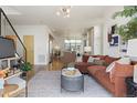 Open concept living room with hardwood floors, a brown sectional sofa, and an open view into the kitchen at 3930 Yates St, Denver, CO 80212