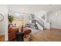 Spacious living room featuring hardwood floors, a modern staircase, and plenty of natural light at 3930 Yates St, Denver, CO 80212