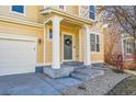 Close-up of a welcoming front porch, featuring a green door with wreath, and stone landscaping at 10622 Racine St, Commerce City, CO 80022