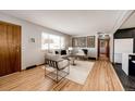 Cozy living room features hardwood flooring, and neutral paint scheme at 1302 S Cape Way, Lakewood, CO 80232