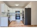 Updated kitchen features stainless steel appliances, white cabinets, and modern backsplash at 3184 S Heather Gardens Way # 302, Aurora, CO 80014