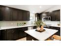 Modern kitchen featuring dark cabinetry, stainless steel appliances, and white countertops at 129 Gordon Pl, Castle Rock, CO 80104