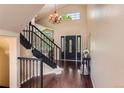 Elegant foyer with hardwood floors, a staircase, and decorative lighting at 9743 Chanteclair Cir, Highlands Ranch, CO 80126