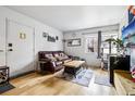 Cozy living room with comfortable seating, natural light, and wood flooring at 3623 S Sheridan Blvd # 12, Denver, CO 80235