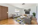 Bright living room featuring a comfortable gray sofa, patterned rug, and modern decor throughout at 7251 Larsh Dr, Denver, CO 80221