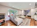 Bright living room with hardwood floors, large bay window, and comfortable sectional sofa at 10621 Julian St, Westminster, CO 80031