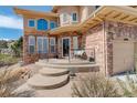 Close-up of the front entrance with a cozy seating area and steps leading to the door at 5830 Jasper Pointe Cir, Castle Pines, CO 80108