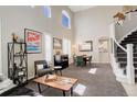 Spacious living room features high ceilings, plentiful natural light, elegant decor, and a staircase at 5830 Jasper Pointe Cir, Castle Pines, CO 80108