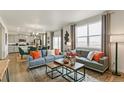 Open living area with gray sofa, coffee table, and large windows at 6531 13Th St, Frederick, CO 80530
