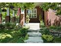 Charming brick front porch with lush landscaping and a welcoming entrance at 7527 E Severn Pl, Denver, CO 80230
