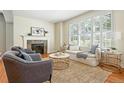 Sunlit living area featuring stylish furniture, a cozy fireplace, and shuttered windows at 7527 E Severn Pl, Denver, CO 80230