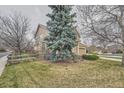 Home featuring a lush lawn with mature shade trees and wood fence at 6172 S Salida Ct, Aurora, CO 80016