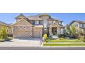Gorgeous two-story home with a well-kept front yard, stone and siding exterior, and a convenient three-car garage at 22198 Boundstone Dr, Parker, CO 80138