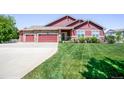 Well-maintained home featuring a lush front lawn, a long driveway, and a two-car garage at 16283 Olive Way, Brighton, CO 80602