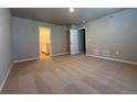 Carpeted bedroom with neutral walls, closet, and a doorway to the bathroom at 48220 Shetland Dr, Bennett, CO 80102