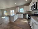 Well-lit kitchen features stainless steel appliances, modern white cabinets, and an island with quartz countertops at 48220 Shetland Dr, Bennett, CO 80102