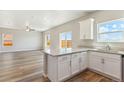 Open-concept kitchen featuring an island, wood laminate floors, hard surface counters, and adjacent living area at 48220 Shetland Dr, Bennett, CO 80102
