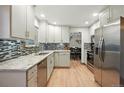 Modern kitchen features stainless steel appliances, granite countertops, and updated cabinetry and backsplash at 15034 E Floyd Ave, Aurora, CO 80014