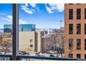 Balcony view overlooking the city skyline, with distant mountains and nearby buildings visible at 888 N Logan St # 5A, Denver, CO 80203