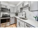 Modern kitchen with stainless steel appliances, white cabinets, subway tile backsplash and granite countertops at 888 N Logan St # 5A, Denver, CO 80203