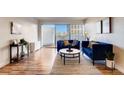 Cozy living room featuring stylish blue sofas, modern decor, and plenty of natural light from a large sliding glass door at 888 N Logan St # 5A, Denver, CO 80203