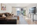 Cozy living room featuring a comfortable brown sectional sofa and a sliding glass door leading to a balcony at 888 N Logan St # 5A, Denver, CO 80203