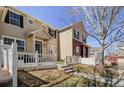 Inviting townhouse featuring a quaint white picket fence and a well-manicured front yard, enhancing curb appeal at 1496 Red Cliff Way, Castle Rock, CO 80109