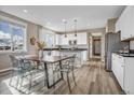 Modern kitchen features white cabinets, stainless steel appliances, and a center island with pendant lighting above at 1171 Nathan Pl, Erie, CO 80026