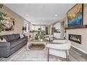 Inviting living area with contemporary furnishings, fireplace, and an open floor plan to the dining and kitchen at 1171 Nathan Pl, Erie, CO 80026