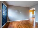 Spacious living room featuring gleaming hardwood floors and a view of the front yard through the front door at 3200 W Chenango Ave, Englewood, CO 80110