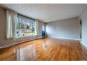Inviting living room with shiny hardwood floors, a large window, and neutral wall color at 3200 W Chenango Ave, Englewood, CO 80110