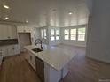 Open-concept kitchen flows into the dining area, featuring a large island and bright lighting at 1733 Fox Trotter Pt, Castle Rock, CO 80104