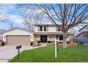 Charming two-story home featuring a well-manicured lawn, double front doors, and attached two-car garage at 3930 S Spruce St, Denver, CO 80237