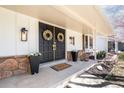Inviting front porch with double doors, stone accents, decorative plants, and a warm welcome mat at 3930 S Spruce St, Denver, CO 80237